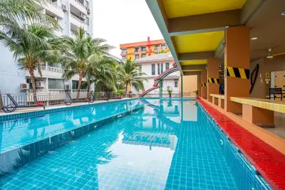 a swimming pool at a hotel with palm trees at MeStyle Place Hotel in Bangkok