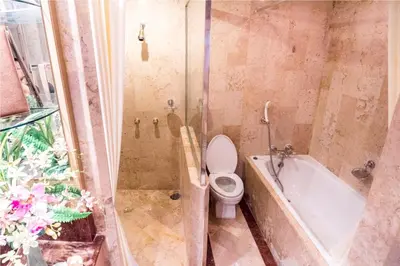 a bathroom with a shower with a toilet and a tub at The Maruay Garden Hotel in Bangkok