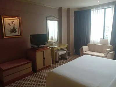 a hotel room with a bed and a television at The Maruay Garden Hotel in Bangkok