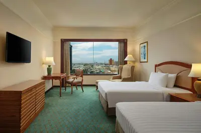 a hotel room with two beds and a window at Jubilee Prestige Hotel Ratchadapisek in Bangkok