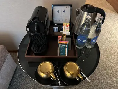 a table with a coffee maker and drinks on it at Jubilee Prestige Hotel Ratchadapisek in Bangkok