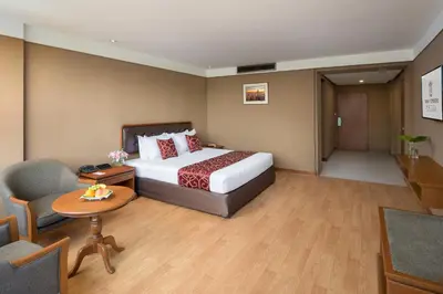 a hotel room with a bed and a table and chairs at Twin Towers Hotel in Bangkok