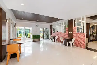 a lobby with tables and chairs and a brick wall at P-Park Suvarnabhumi in Bangkok