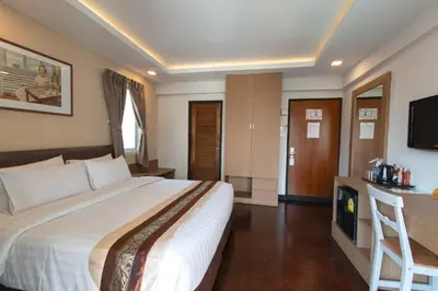 a hotel room with a large bed and a television at Stable Lodge - SHA Certified in Bangkok