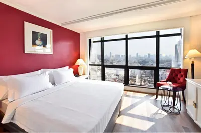 a bedroom with a large white bed and a red wall at Grand China Bangkok in Bangkok