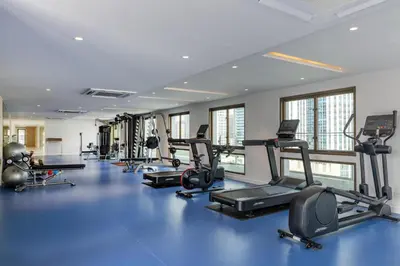 a gym with several treadmills and elliptical machines at Radisson Hotel Chateau de Bangkok in Bangkok