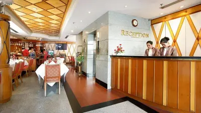 a restaurant with two men standing at a bar at Majestic Suites Hotel in Bangkok