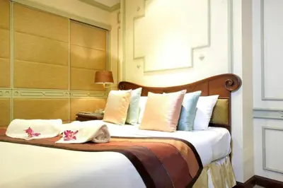 a bedroom with a large bed with pillows at Majestic Suites Hotel in Bangkok