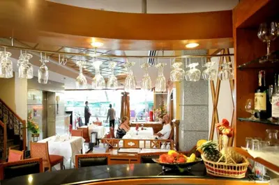 a restaurant with tables and chairs and chandeliers at Majestic Suites Hotel in Bangkok