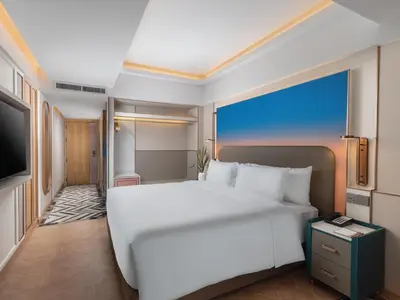 a bedroom with a large white bed and a television at Pipa Hotel Bangkok Sukhumvit 11 in Bangkok