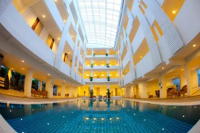 a swimming pool in a building with a ceiling at Trang Hotel Bangkok - SHA Plus in Bangkok
