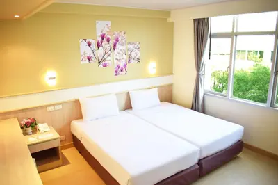 a hotel room with two beds and a window at Trang Hotel Bangkok - SHA Plus in Bangkok
