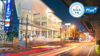 a city street at night with buildings and cars at Trang Hotel Bangkok - SHA Plus in Bangkok