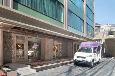 a white van parked in front of a building at Valia Hotel Bangkok in Bangkok