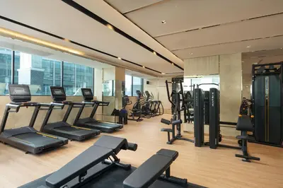 a gym with a bunch of treadmills and machines at Valia Hotel Bangkok in Bangkok