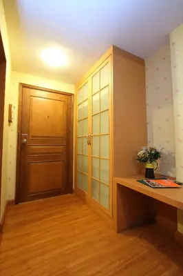 a room with a wooden cabinet and a door at Silom Avenue Inn in Bangkok