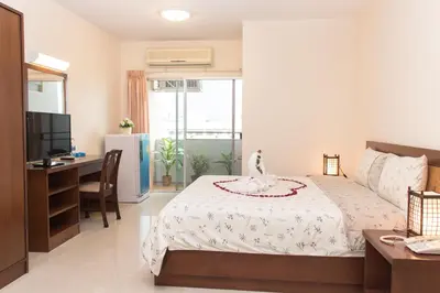 a bedroom with a bed and a desk and a television at K.V.Mansion in Bangkok