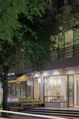 a store front with a person sitting in the window at @Home Residence in Bangkok
