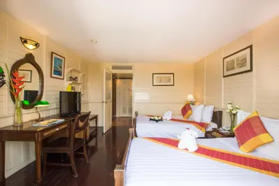 a hotel room with two beds and a desk at Buddy Lodge, Khaosan Road in Bangkok