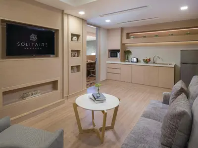 a living room with a couch and a table at Solitaire Bangkok Sukhumvit 11 in Bangkok