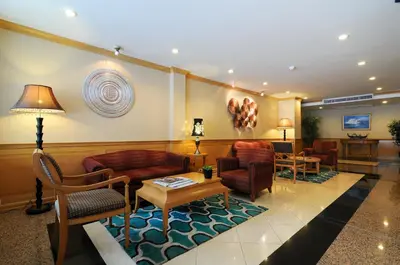 a lobby with couches and chairs and a table at Admiral Suites Bangkok in Bangkok