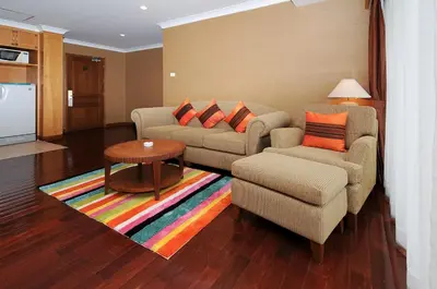 a living room with a couch and two chairs and a table at Admiral Suites Bangkok in Bangkok
