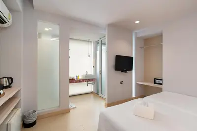 a white room with a bed and a television at Metz Pratunam in Bangkok