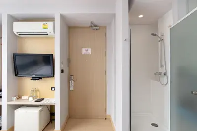 a bathroom with a shower and a tv and a shower at Metz Pratunam in Bangkok