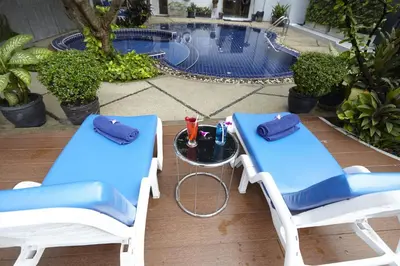 two chairs and a table in front of a pool at Anya Nana at Sukhumvit Bangkok in Bangkok