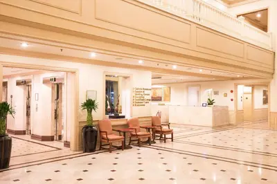a lobby with a table and chairs in a building at Ramada by Wyndham D MA Bangkok in Bangkok