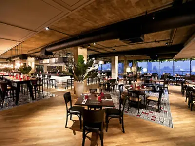 a restaurant with tables and chairs in a room at Pullman Bangkok Hotel G in Bangkok