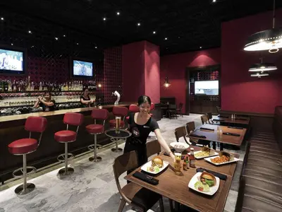 a woman standing in a restaurant with a plate of food at Pullman Bangkok Hotel G in Bangkok