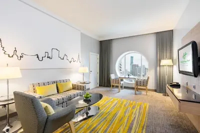a living room with a couch and a table at Holiday Inn Bangkok Silom by IHG in Bangkok
