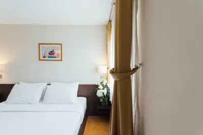 a hotel room with a bed and a window at Seasons Siam Hotel in Bangkok