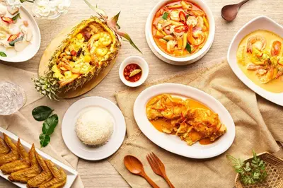 a table topped with plates of food and rice at Feung Nakorn Balcony Rooms and Cafe in Bangkok