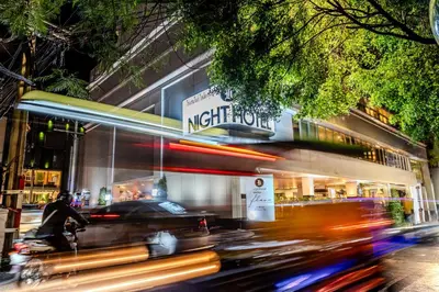 a city street with a night view of a night store at Night Hotel Bangkok - Sukhumvit 15 in Bangkok
