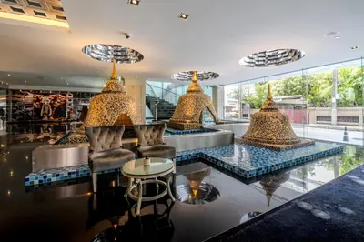 a lobby with a bar with a table and chairs at Night Hotel Bangkok - Sukhumvit 15 in Bangkok