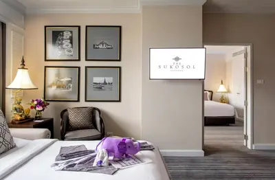 a hotel room with a purple bag on a bed at The Sukosol Hotel in Bangkok