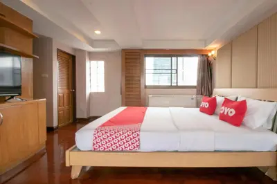 a bedroom with a large bed with red pillows at Hotel Win Long in Bangkok
