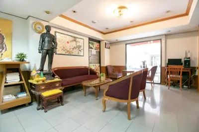 a living room with a statue of a man on the wall at Hotel Win Long in Bangkok