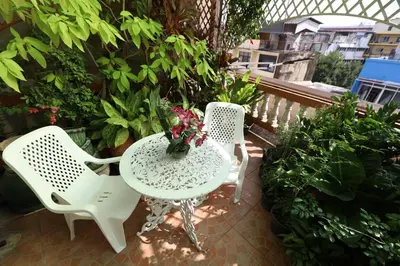 two chairs and a table with flowers on a patio at Thai Cozy House in Bangkok