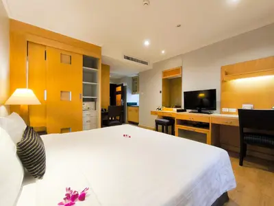 a hotel room with a large white bed and a desk at The Key Bangkok Hotel in Bangkok