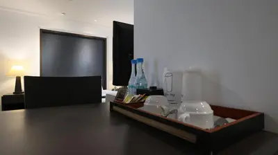 a table with a tray with bottles on top of it at The Key Bangkok Hotel in Bangkok