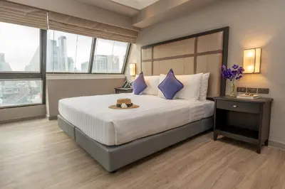 a bedroom with a large bed with a teddy bear on it at NH Bangkok Sukhumvit Boulevard in Bangkok
