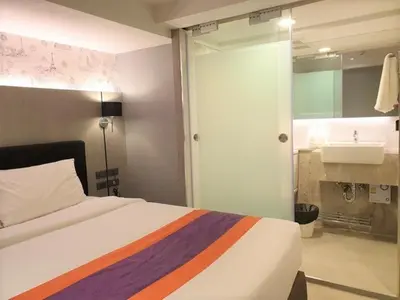 a bedroom with a bed and a bathroom with a sink at Studio Ekamai in Bangkok