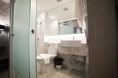 a bathroom with a white toilet and a sink at Studio Ekamai in Bangkok
