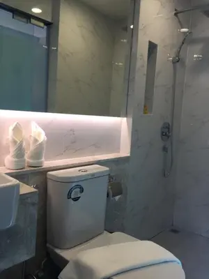 a bathroom with a toilet and a shower and a sink at Studio Ekamai in Bangkok