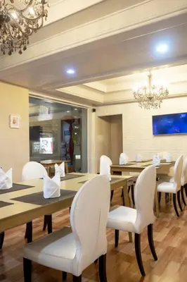a dining room with a table and white chairs at Baiyoke Boutique Hotel in Bangkok