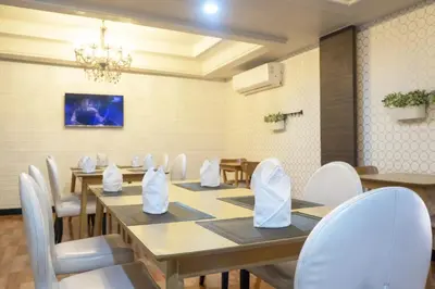 a dining room with wooden tables and white chairs at Baiyoke Boutique Hotel in Bangkok