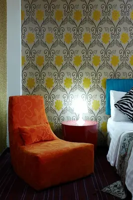 an orange chair sitting in front of a bedroom at Baiyoke Boutique Hotel in Bangkok